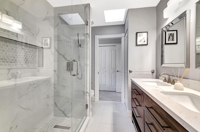 bathroom with walk in shower, vanity, toilet, and a skylight