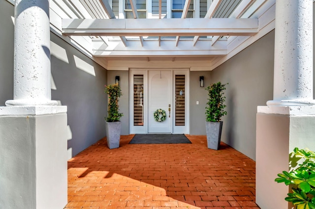 view of exterior entry with a pergola