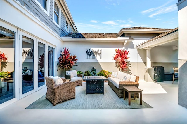 view of patio with an outdoor living space with a fire pit and french doors