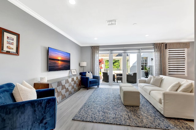 living room featuring light hardwood / wood-style flooring and ornamental molding