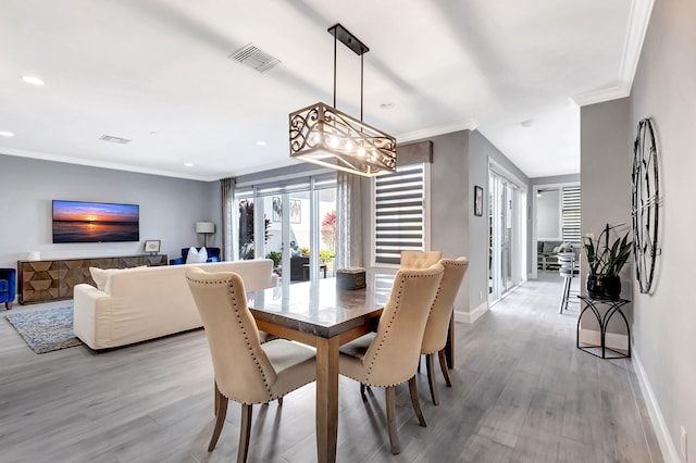 dining space with french doors, ornamental molding, and light hardwood / wood-style floors