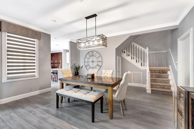 dining area featuring crown molding, wood-type flooring, and beverage cooler