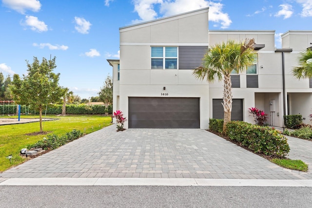 contemporary home with a garage and a front yard