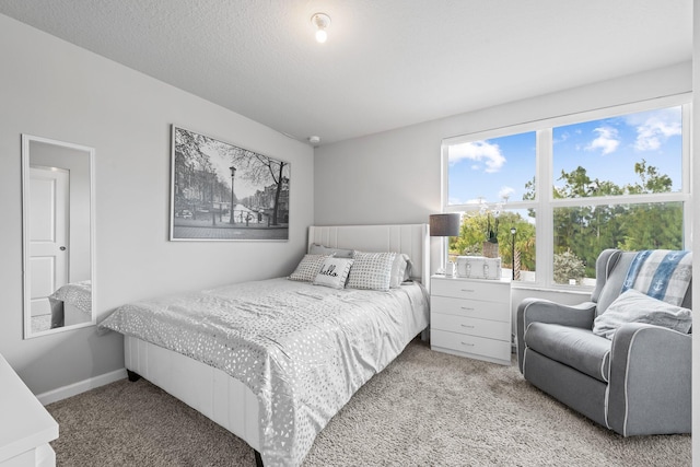 bedroom featuring light carpet and a textured ceiling