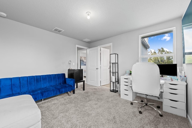 carpeted office space featuring a textured ceiling