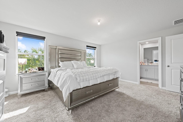 bedroom featuring light colored carpet and ensuite bathroom