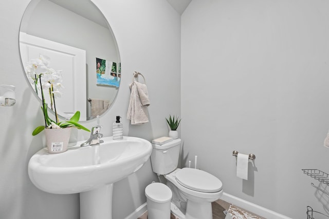 bathroom with hardwood / wood-style flooring, toilet, and sink