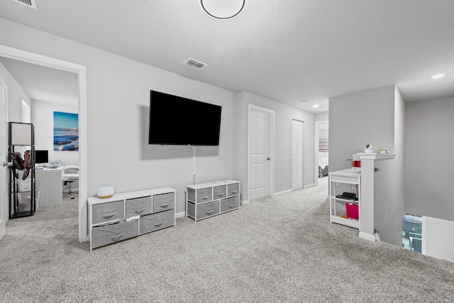 living room featuring light carpet and a textured ceiling