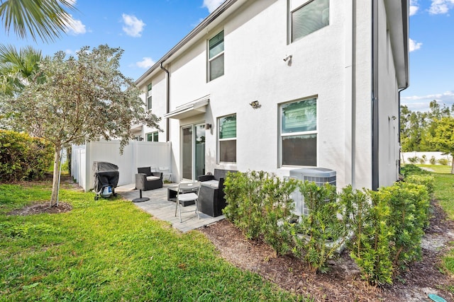 back of house with outdoor lounge area, a patio area, and a lawn