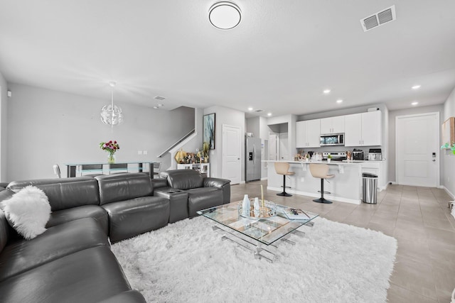 tiled living room with an inviting chandelier