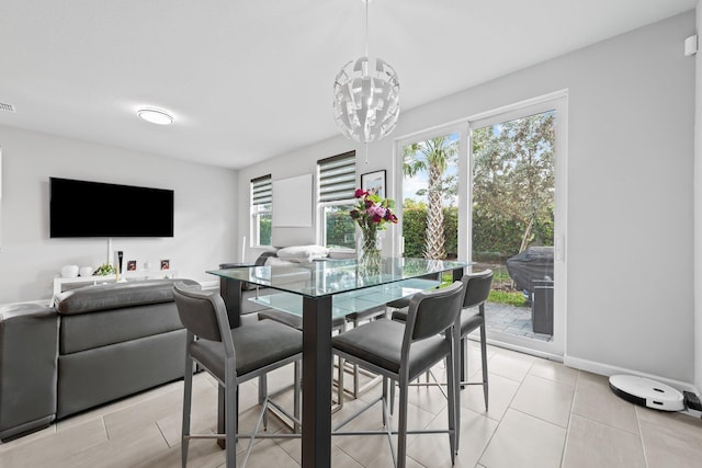 dining space with light tile patterned flooring, plenty of natural light, and a chandelier