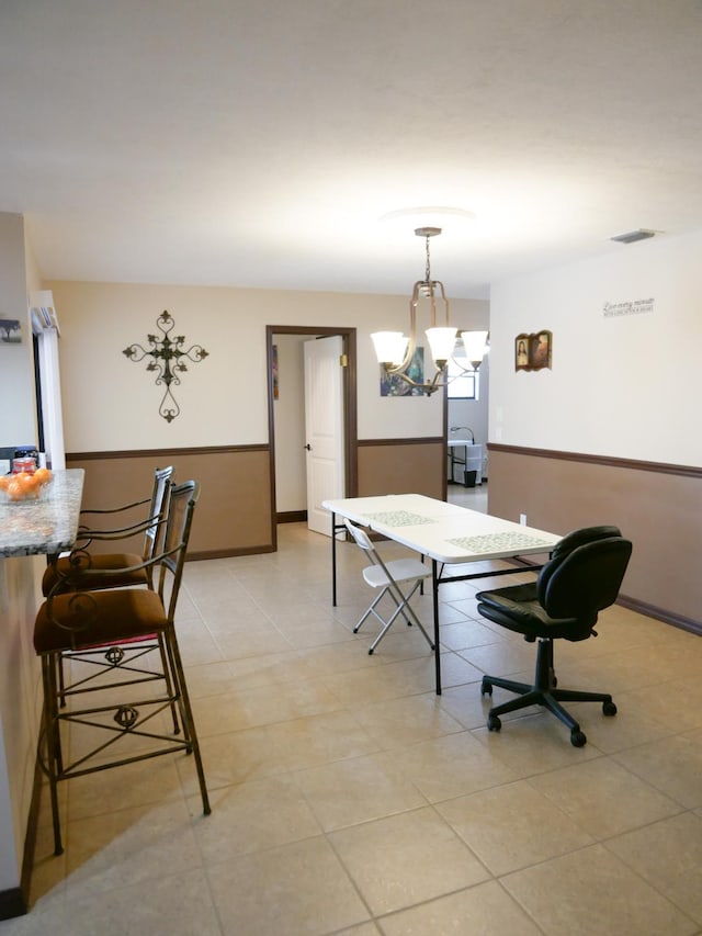 dining area featuring light tile patterned flooring and an inviting chandelier