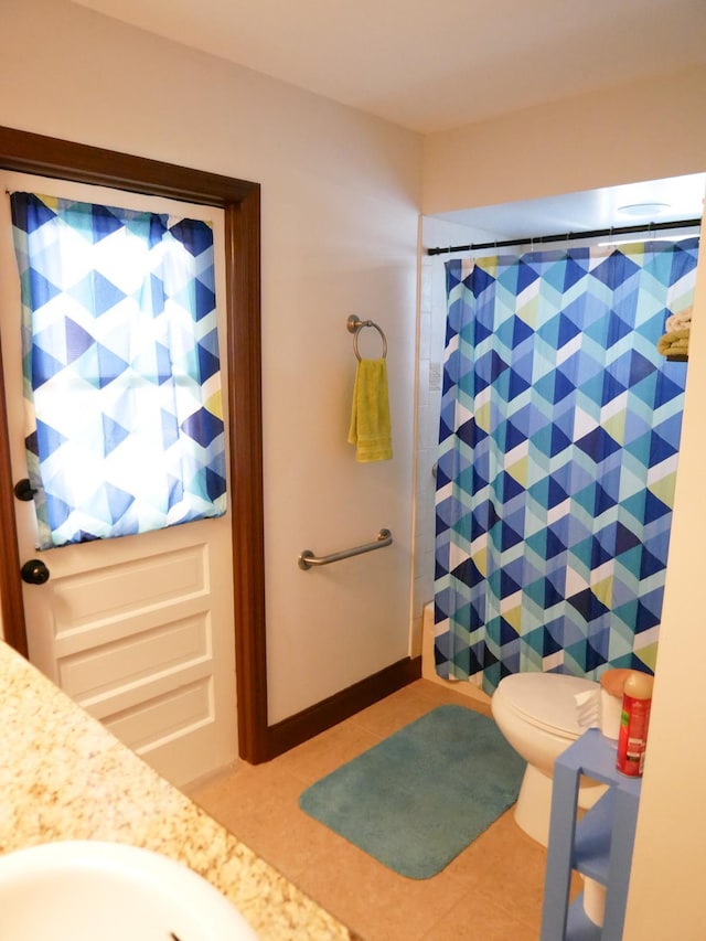 bathroom featuring tile patterned flooring, toilet, vanity, and walk in shower