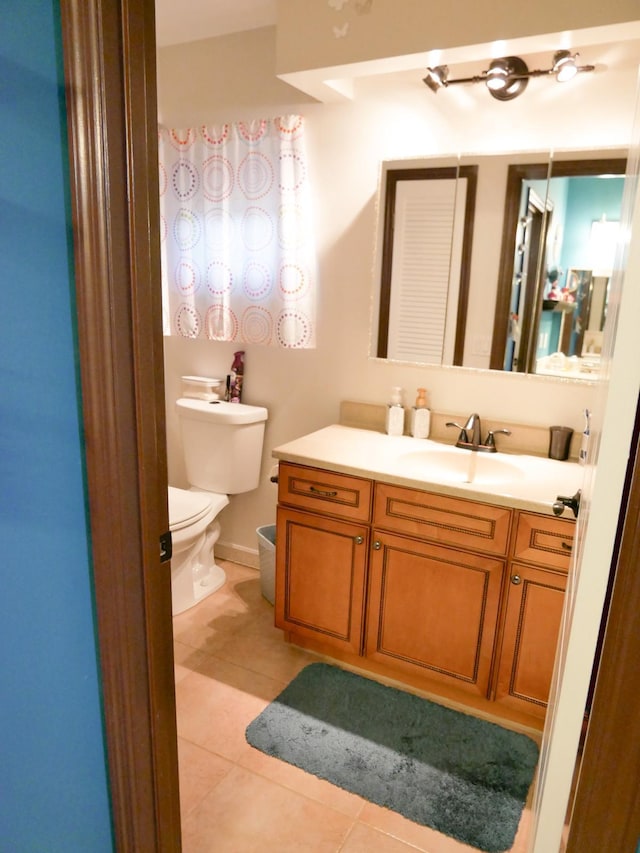 bathroom featuring tile patterned flooring, vanity, and toilet