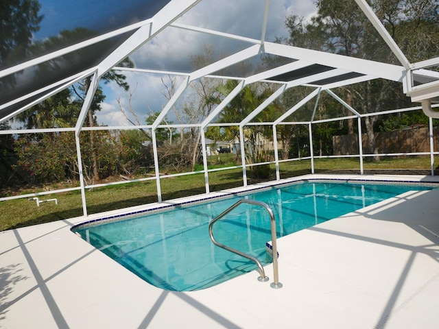 view of swimming pool featuring a yard, a lanai, and a patio