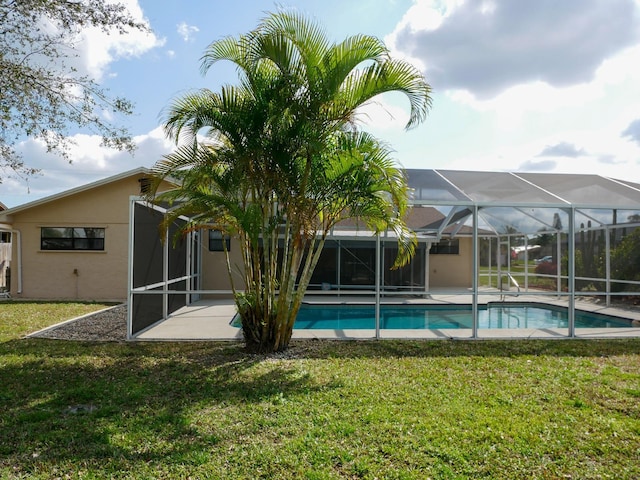 back of property with a yard, a lanai, and a patio