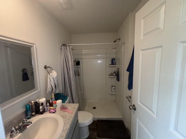 bathroom featuring vanity, curtained shower, and toilet