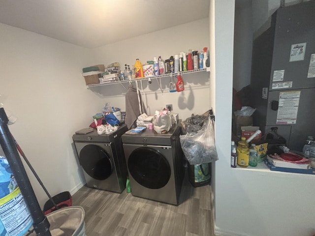 laundry room with heating unit, hardwood / wood-style floors, and washer and clothes dryer