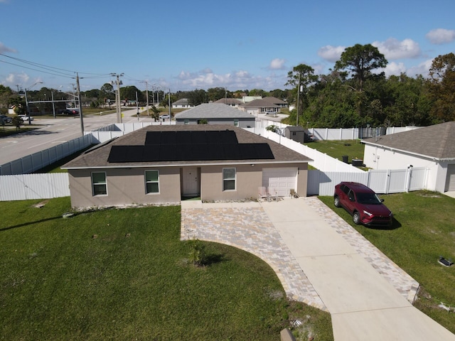 view of front of house featuring a garage, a front yard, and solar panels