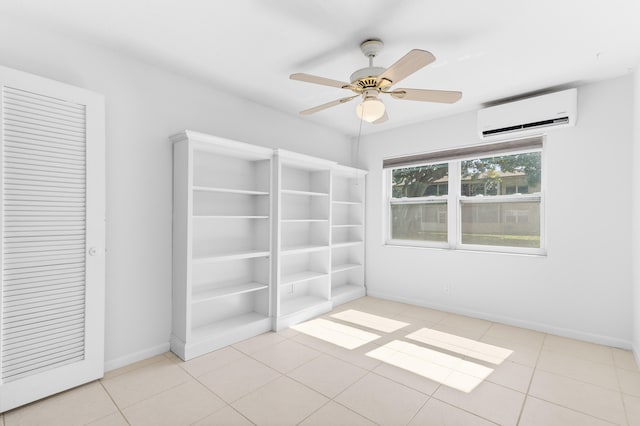 tiled spare room with a wall mounted AC and ceiling fan