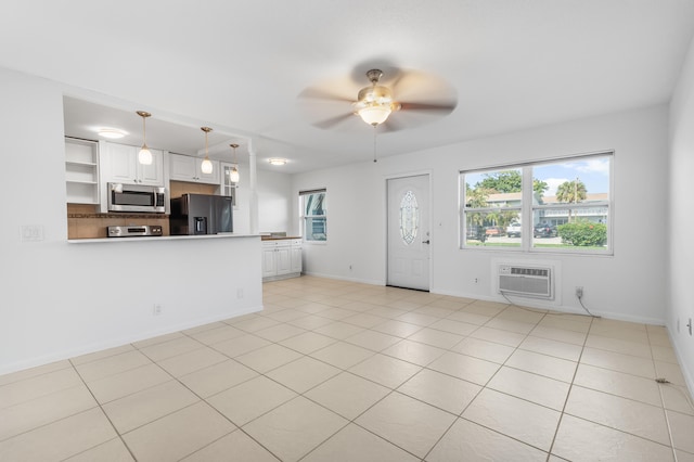 unfurnished living room featuring a wall unit AC, ceiling fan, and light tile patterned flooring