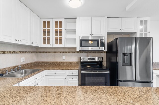 kitchen with white cabinetry, appliances with stainless steel finishes, sink, and tasteful backsplash