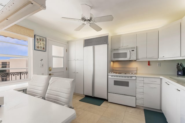 kitchen with sink, white cabinets, light tile patterned floors, ceiling fan, and white appliances