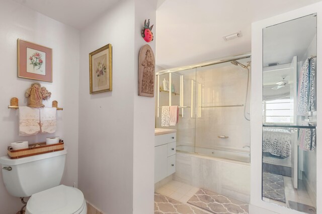 full bathroom featuring enclosed tub / shower combo, vanity, and toilet