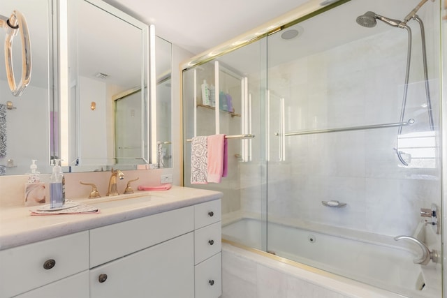 bathroom featuring bath / shower combo with glass door and vanity