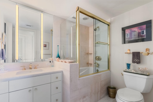 full bathroom with bath / shower combo with glass door, vanity, and toilet