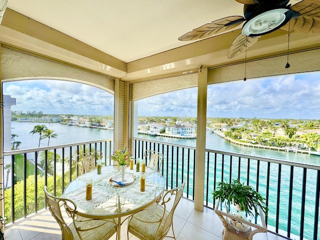 balcony featuring a water view and ceiling fan