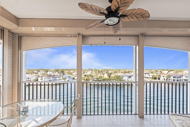 unfurnished sunroom featuring a water view and ceiling fan