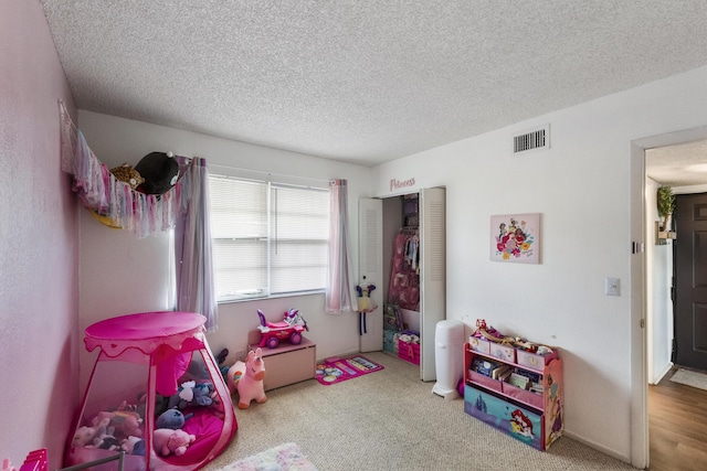 playroom featuring carpet floors and a textured ceiling