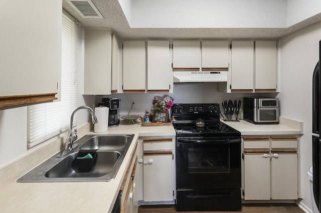 kitchen featuring black electric range oven, sink, a textured ceiling, and white cabinets