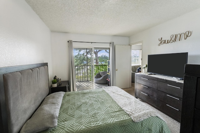 bedroom with access to exterior, a textured ceiling, and carpet flooring