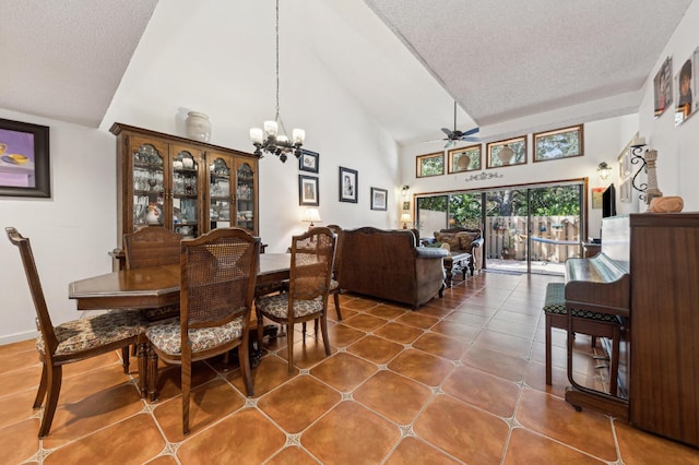 tiled dining room featuring ceiling fan with notable chandelier, high vaulted ceiling, and a textured ceiling