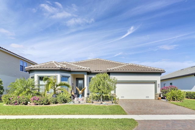 mediterranean / spanish-style house featuring a garage and a front yard