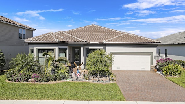 mediterranean / spanish home with a garage and a front lawn