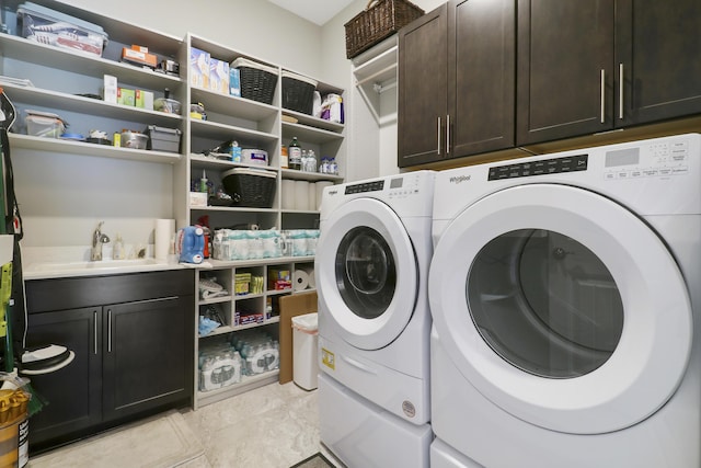 laundry room with cabinets, washer and dryer, and sink