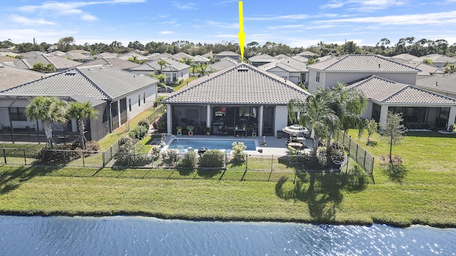 back of house featuring a water view, a yard, and a sunroom