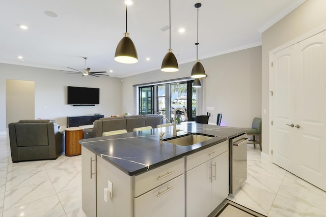 kitchen featuring sink, white cabinetry, crown molding, decorative light fixtures, and an island with sink