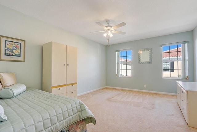 bedroom featuring light carpet, multiple windows, and ceiling fan