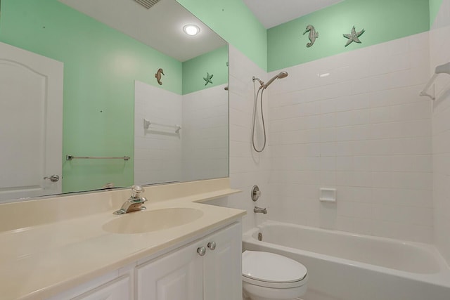 full bathroom featuring vanity, tiled shower / bath combo, and toilet