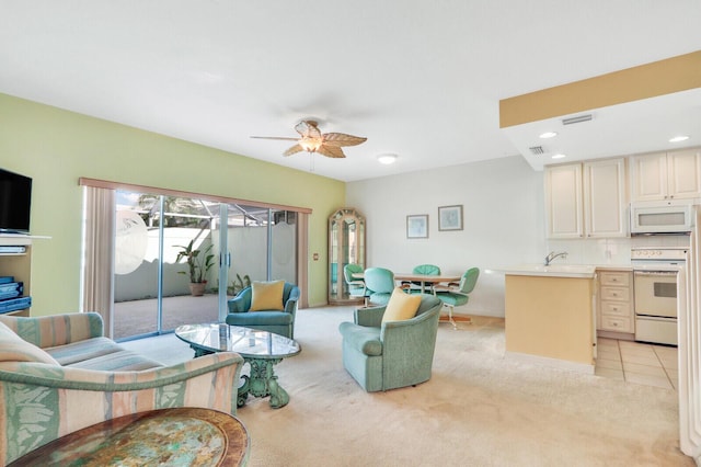 carpeted living room featuring ceiling fan