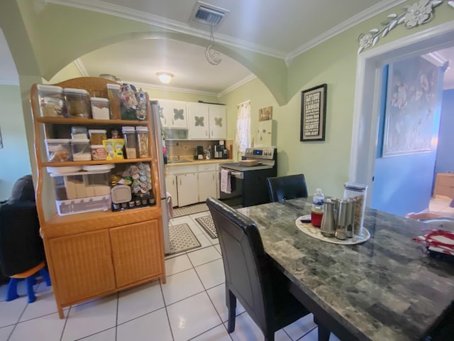 dining space with crown molding and light tile patterned floors