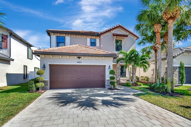 mediterranean / spanish home featuring a garage and a front yard