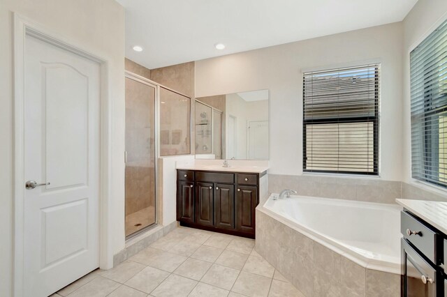 bathroom featuring tile patterned flooring, vanity, plenty of natural light, and plus walk in shower