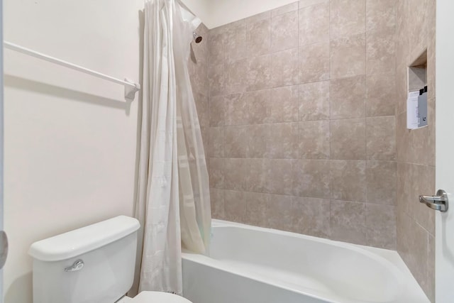 bathroom featuring shower / tub combo and toilet