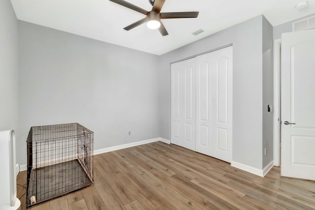 unfurnished bedroom with ceiling fan, light hardwood / wood-style floors, and a closet