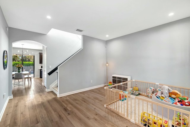 playroom featuring wood-type flooring and a chandelier